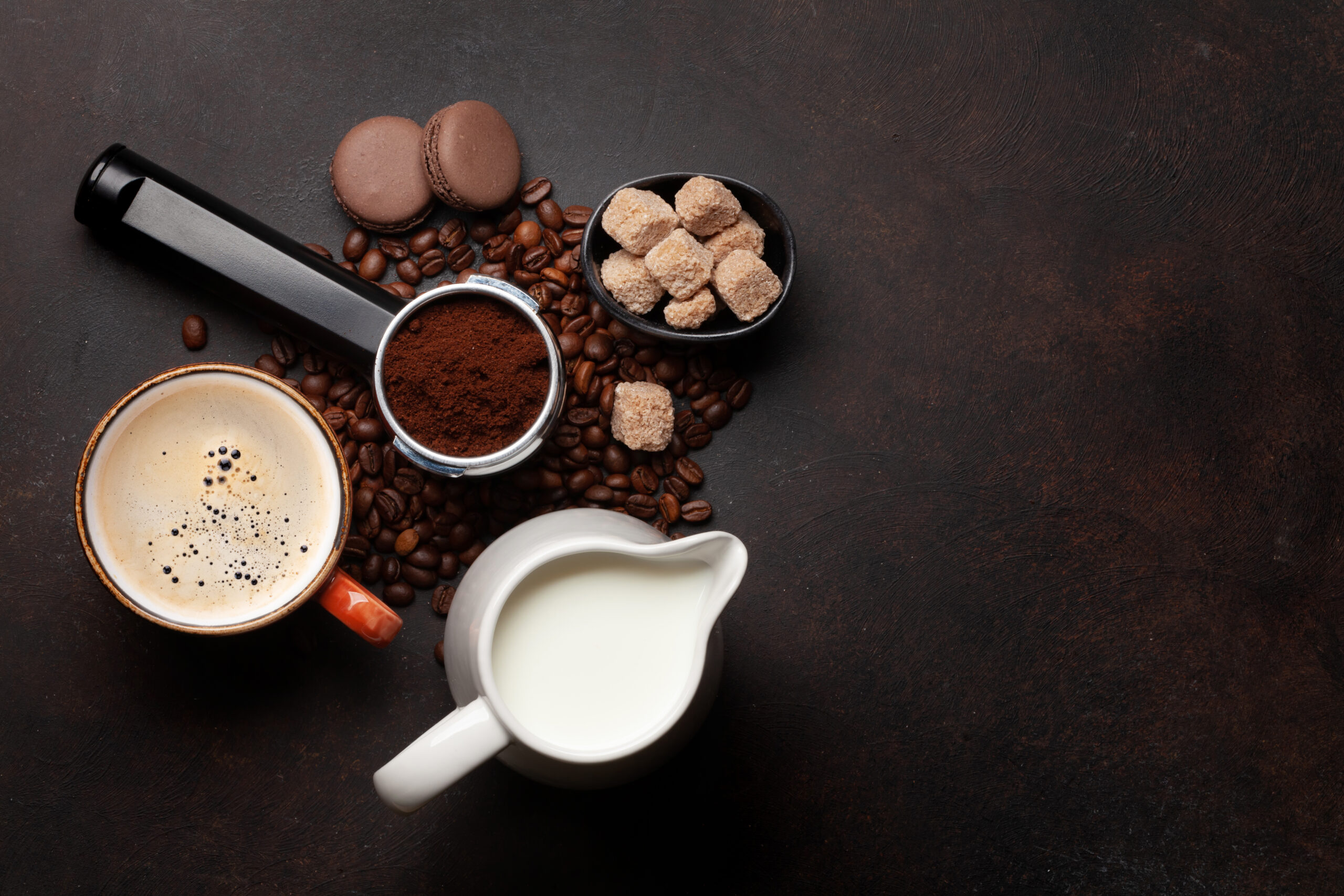Fresh cappuccino coffee, roasted coffee beans and milk. Top view flat lay with copy space
